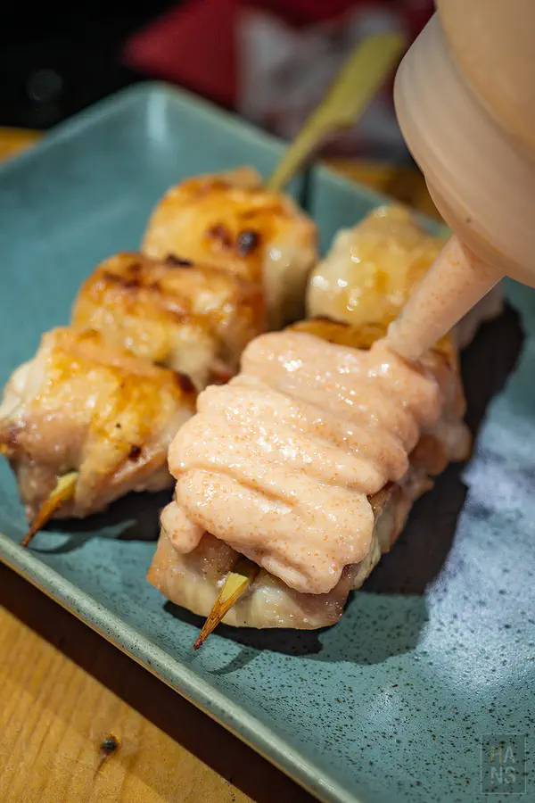 鋪滿明太子醬的雞腿肉串特寫