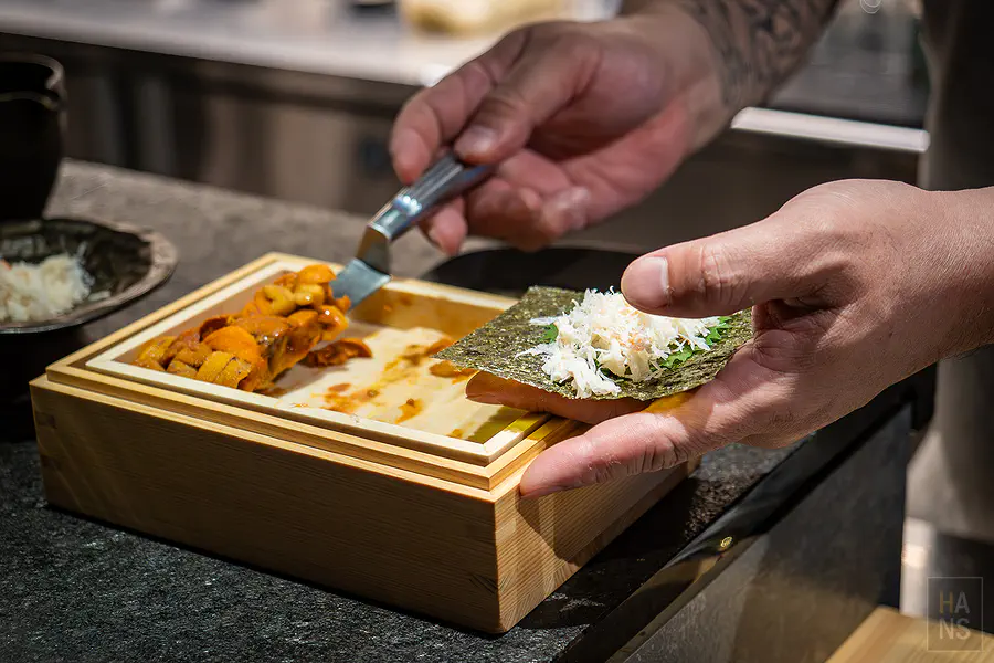 師傅現做鋪滿海膽與松葉蟹肉的手卷