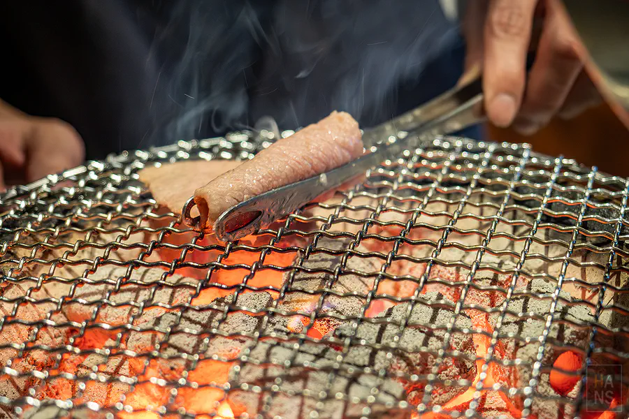 店長熟練地將腿三角肉片捲起