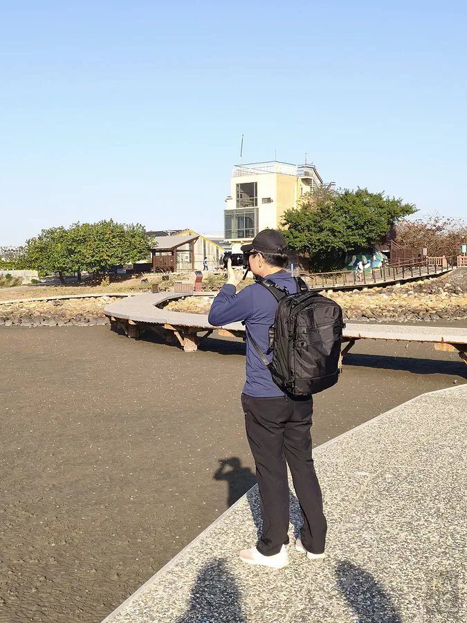 翰斯在海邊木棧道揹著包包實際拍攝,雙手解放的自由感