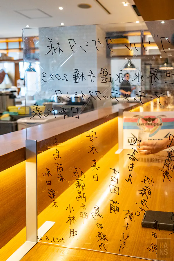 餐廳座位區透明壓克力隔板上的體育選手親筆簽名