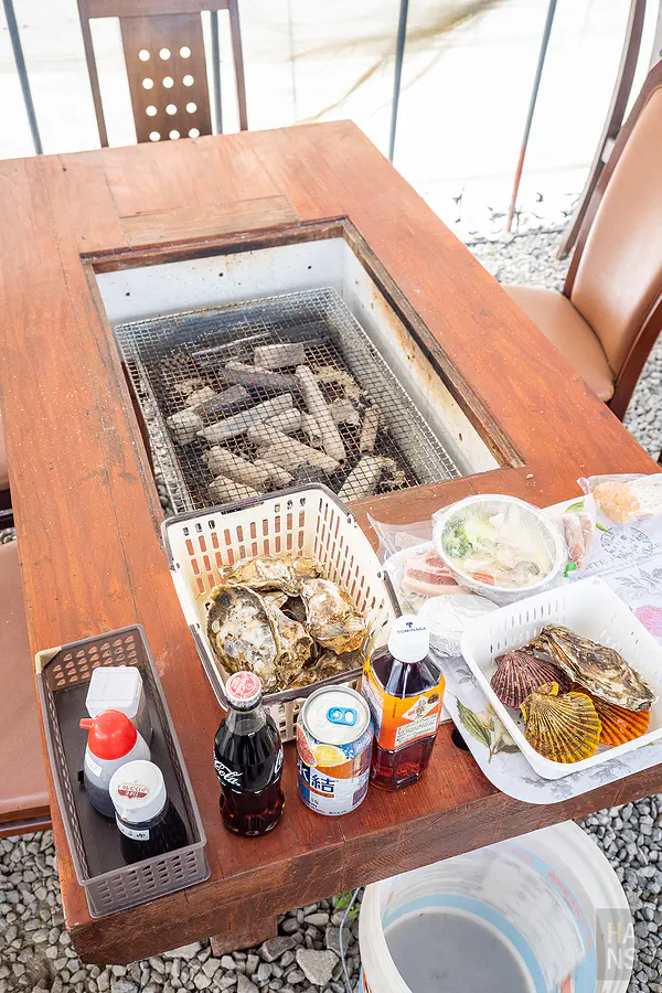 餐桌上擺滿了挑選好的生蠔與烤肉食材