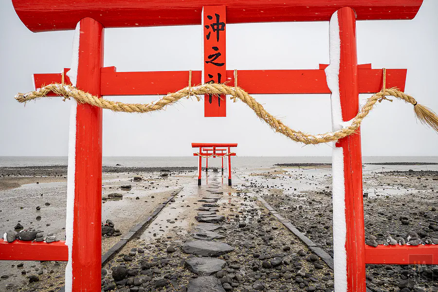 雪天從主鳥居望向沿參道延伸入海的海中鳥居