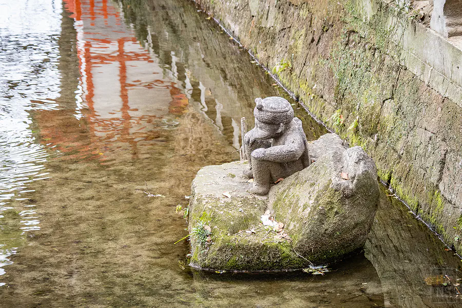 佐嘉神社河道石垣上坐在水邊的河童石像