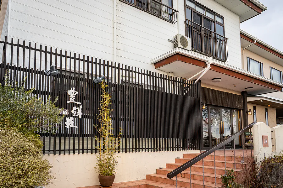 豐洋莊旅館入口招牌與黑色格柵外牆