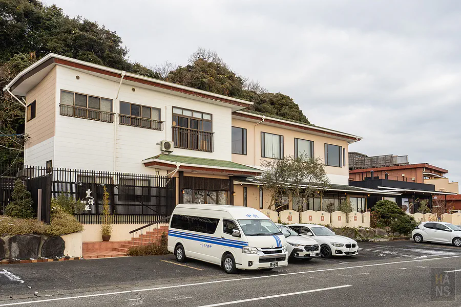 豐洋莊旅館外觀與接駁巴士停靠的停車場
