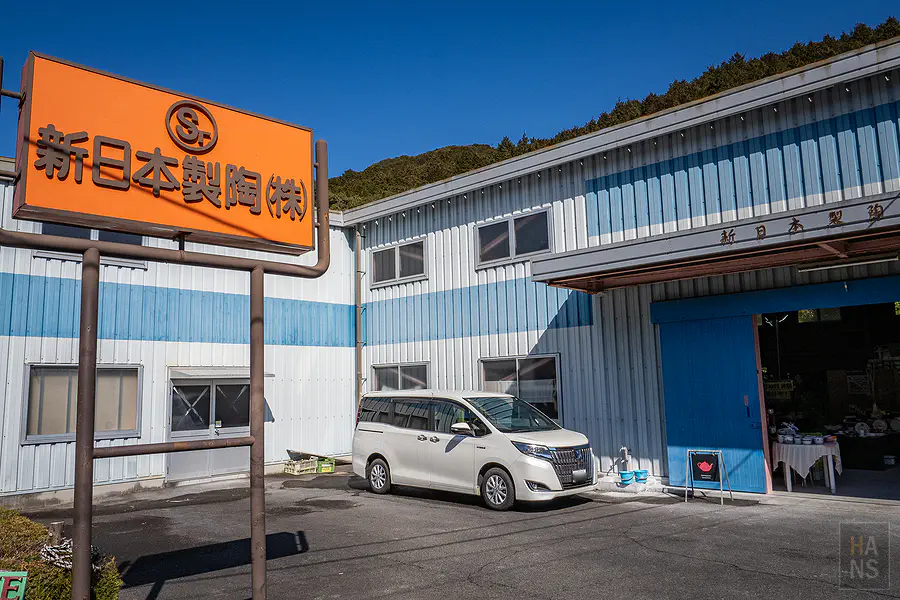 新日本製陶工廠外牆的橘色招牌與藍白配色建築外觀