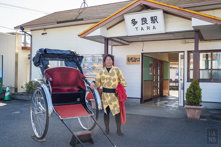 ISYOU車伕中島先生穿黃色法被站在多良車站前的人力車旁