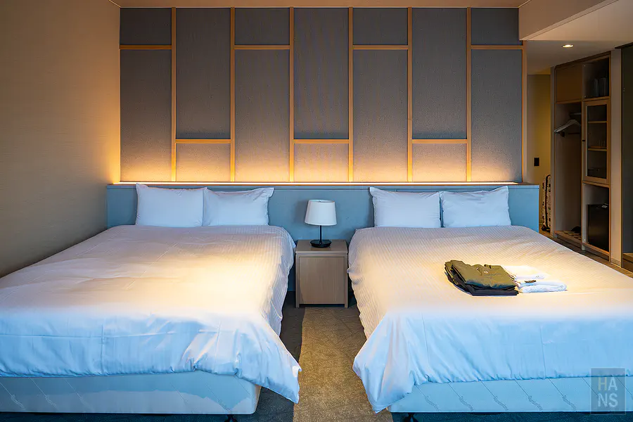OND HOTEL客房雙床與床頭櫃，床上擺放館內服與毛巾