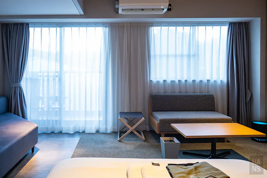 OND HOTEL客房窗邊客廳區，紗簾透光的舒適空間