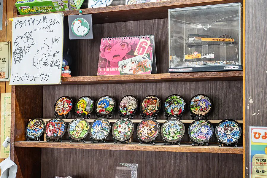牆上展示的佐賀偶像是傳奇聯名瓷盤與聲優簽名板