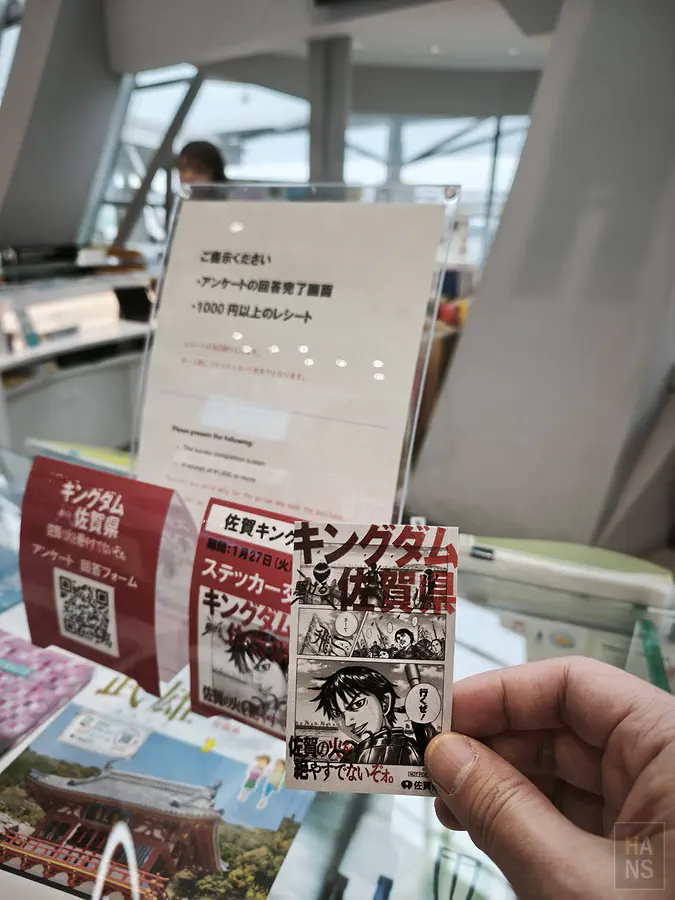 翰斯在佐賀機場一樓櫃台憑消費收據與問卷領取的王者天下限量聯名貼紙