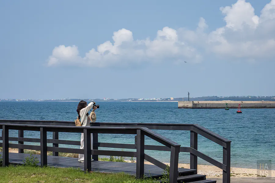 遊客在龍門閉鎖陣地海景步道拍攝湛藍海景的背影
