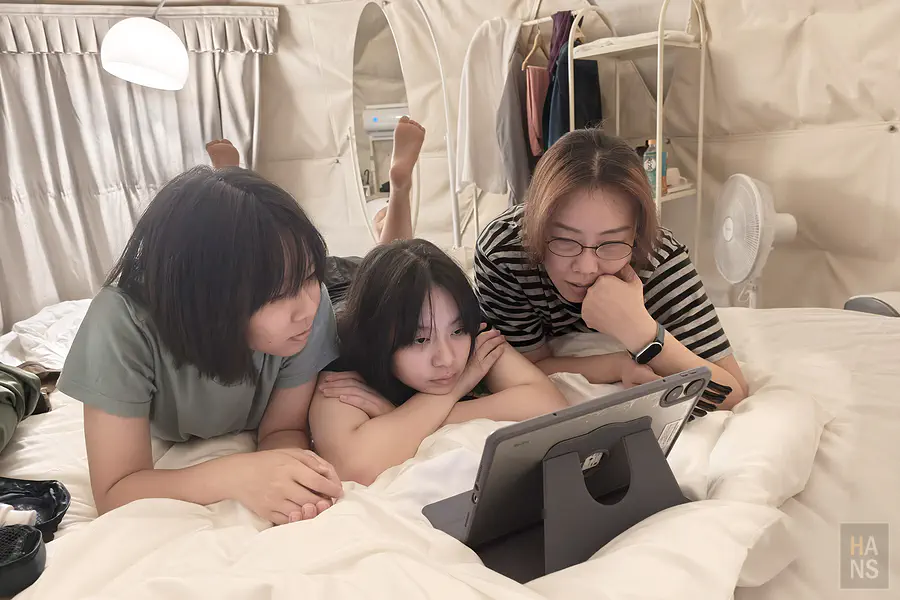 母女三人在帳篷內用平板看電影