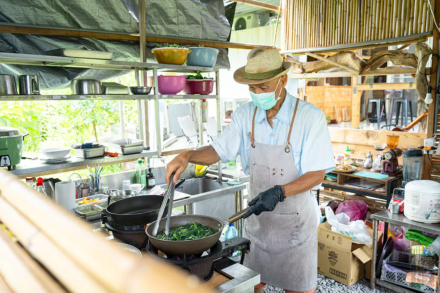藝蔬咖食坊老闆在開放式廚房現炒台東在地野菜