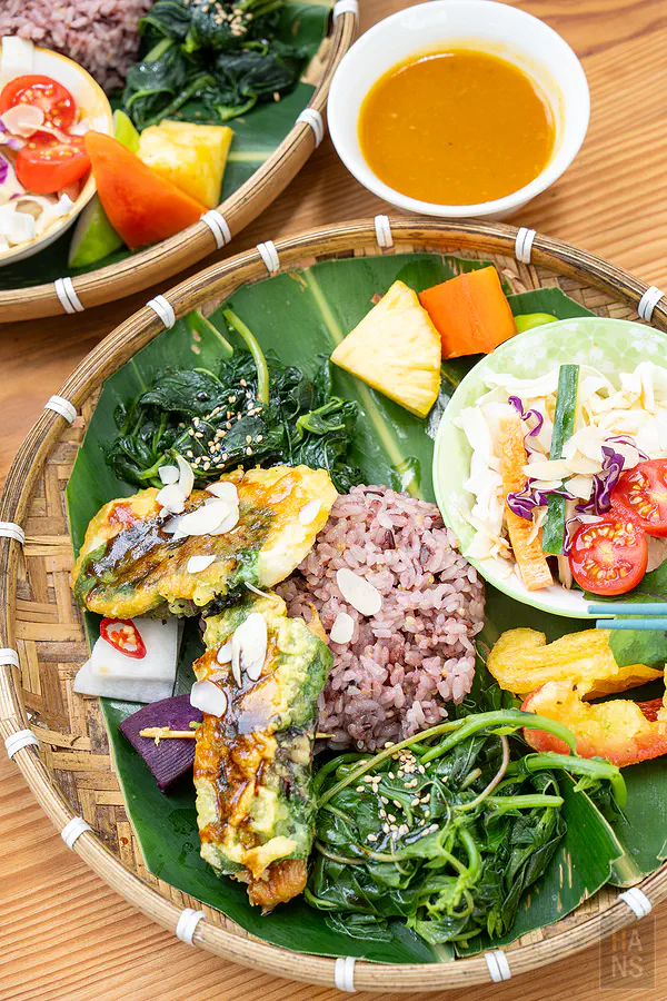 藝蔬咖食坊阿美族野菜蔬食餐盤，竹編盤上擺滿紫米飯與當季野菜