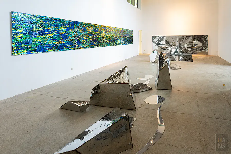 賴純純工作室展場，藍綠色長幅畫作與鏡面幾何雕塑