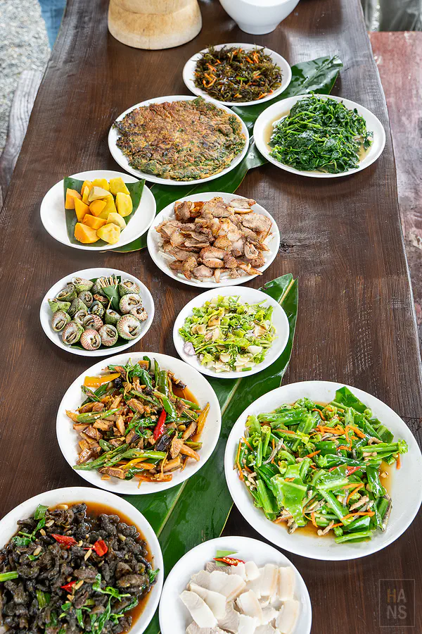 達麓岸部落屋滿桌阿美族風味料理，野菜與烤肉沿長桌排開