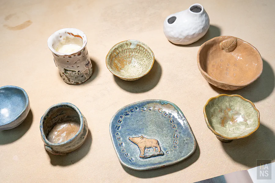 心燈窯坊手作陶器作品，溫潤釉色的杯碗與山豬圖案盤