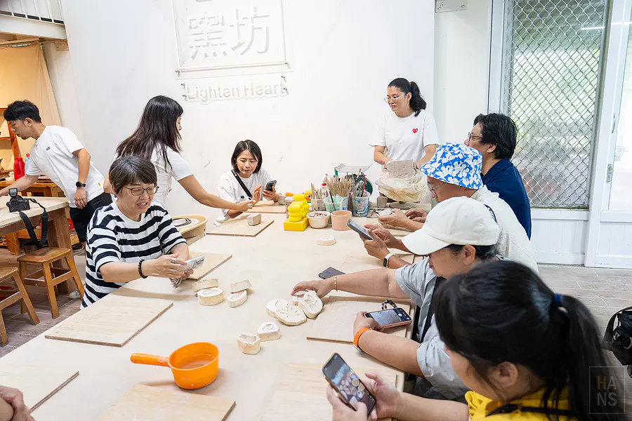 心燈窯坊陶藝體驗教室，學員圍著長桌手作陶器