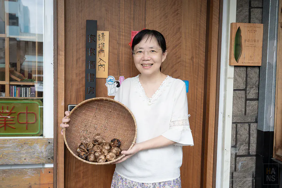 家家酒書房主人天瑜捧著黑蒜頭在門口合照