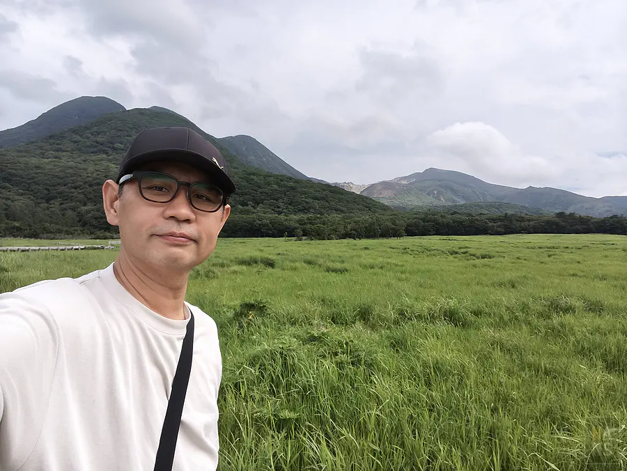 翰斯在蓼原濕原前與九重連山合影的涼夏大分紀念照