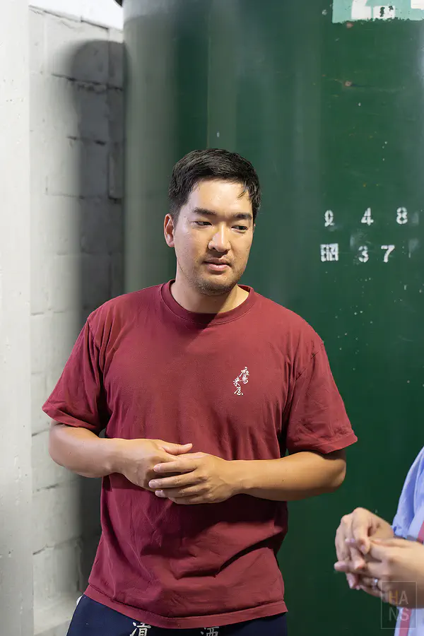 鷹來屋六代目當家於綠色酒槽前留影