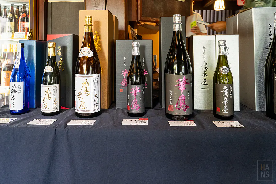 鷹來屋店舖木製展示架上的清酒與陶器