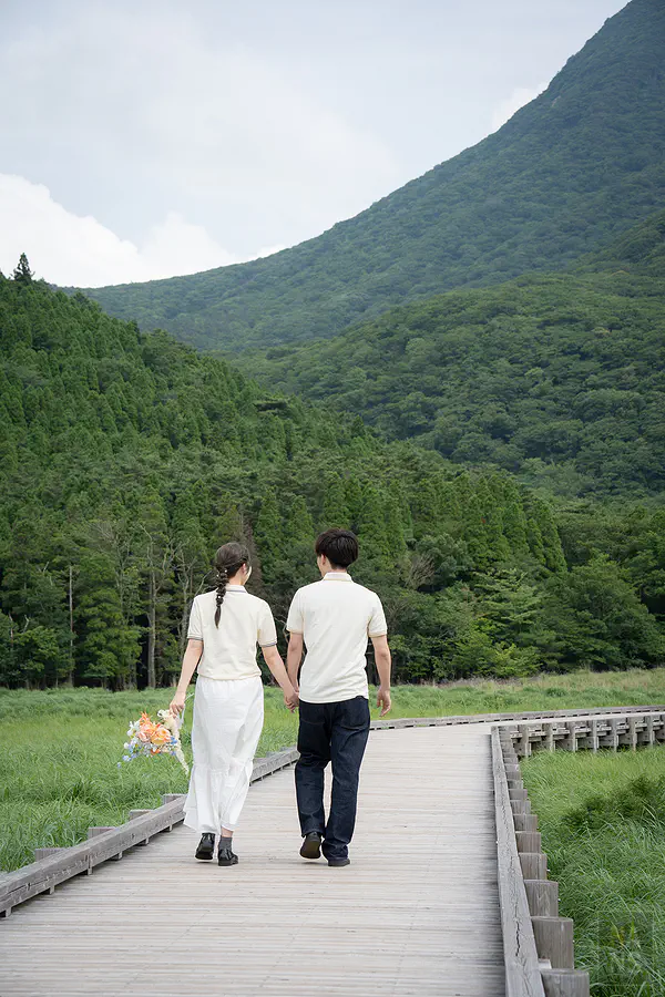 蓼原濕原木道上新人牽手走向九重連山的婚紗背影照