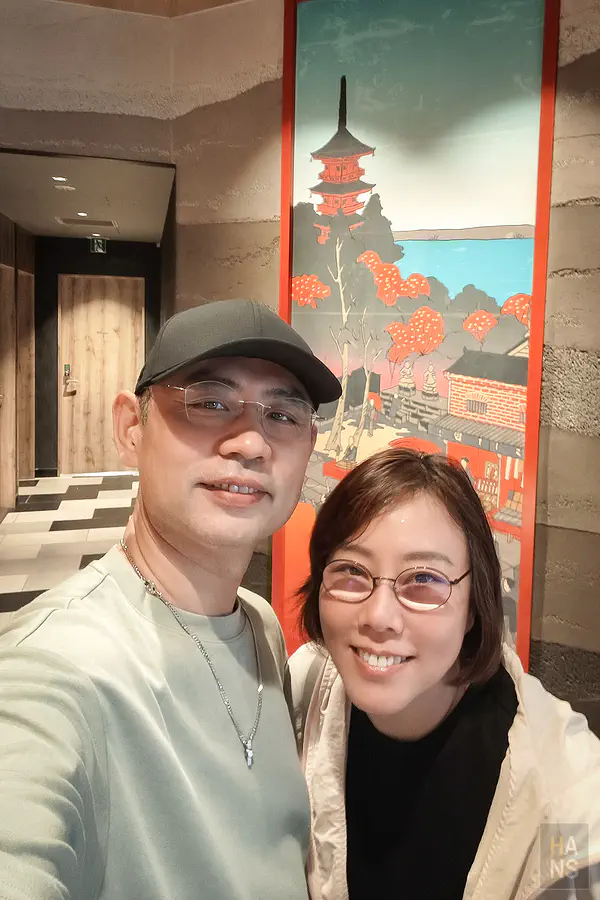 翰斯穿淺灰綠 T-shirt 戴 AWNL 隕石項鍊與 Kay 在東京飯店合照