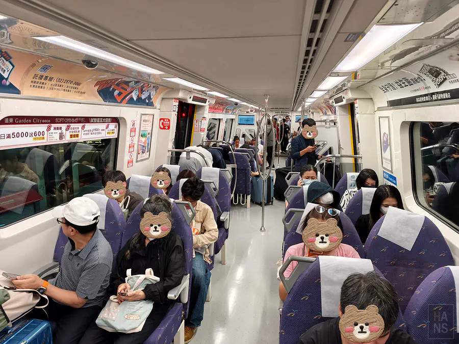 桃園機場捷運直達車車廂內部，紫色座椅與寬敞走道