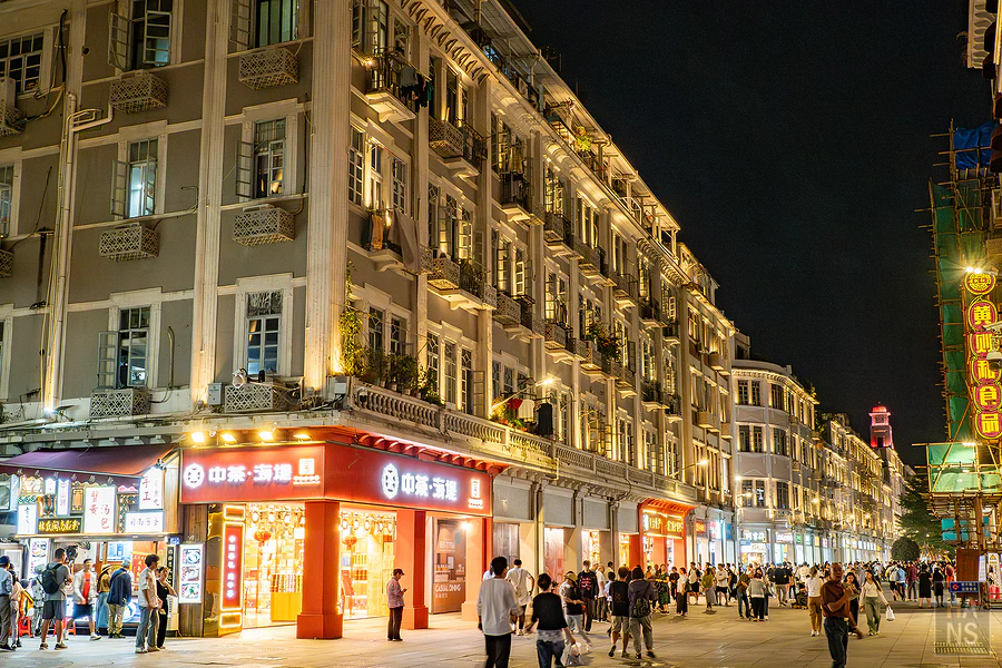 夜晚打上暖色燈光的復古建築與中茶海堤紅色招牌